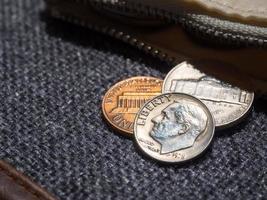 monedas de dólar estadounidense colocadas fuera de la billetera. foto