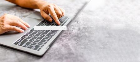 A man's hand rests on a laptop to use for job searching over the Internet. The concept for working from home, touch, website,  networking,  typing. Copy space on right for design. Blurred background photo