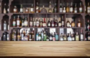 Wooden board empty table in front of blurred ligour drink background photo