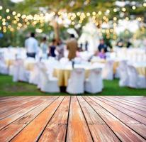 mesa de madera vacía con gente borrosa fiesta al aire libre foto