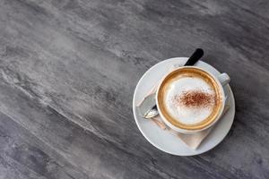 taza de café caliente en la mesa de mármol en la cafetería para beber foto