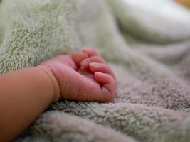 Baby hand on gray blanket. newborns feel safe and warm. Selective soft focus. photo