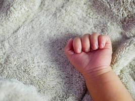 Baby hand on gray blanket. newborns feel safe and warm. Selective soft focus. photo