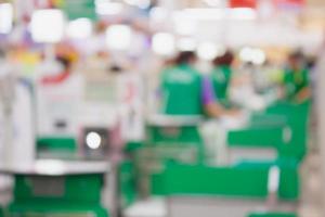 supermarket checkout payment terminal with customers blurred background photo