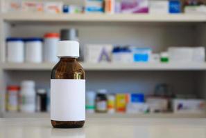 Blank white label of medicine bottle with blur shelves of drug in the pharmacy drugstore background photo