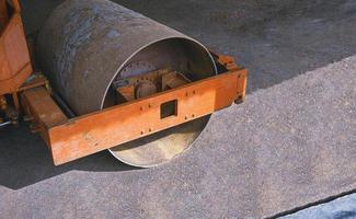 High angle and side view of the old steel wheel roller compacting soil in construction site area photo