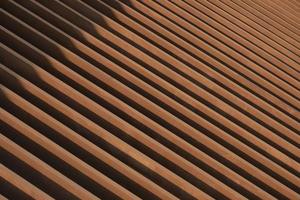 Sunlight and shadow on surface of the old artificial wooden lath in abstract diagonal pattern and perspective view for background design and architecture concept photo