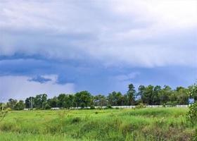 black clouds rainy season and green field photo