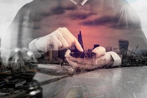 double exposure of justice and law concept.Male judge in a courtroom with the gavel,working with smart phone computer on wood table,London architecture city photo