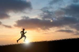 silueta de hombre corriendo en el atardecer. silueta para un corredor entrenando por la noche. puestas de sol foto