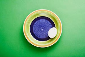 Colorful plate on green background with a white egg. photo