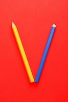 Yellow and blue pencils on vivid red background. photo