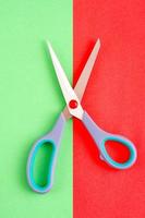 Minimalist image of scissors on red and green background.