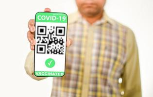 hombre que sostiene un teléfono inteligente para mostrar la vacuna del pasaporte de la vacuna de la aplicación contra el coronavirus o covid-19. el concepto para prevenir la propagación del coronavirus. y demostraciones de seguridad después de la vacunación. foto