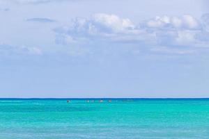 Red canoes on the sea panorama Playa del Carmen Mexico. photo