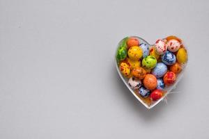 forma de corazón llena de huevos de colores para el día de pascua con espacio de copia foto