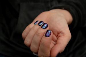 manos de mujer bien arregladas con manicura de brillo negro. revestimiento de esmalte de gel foto