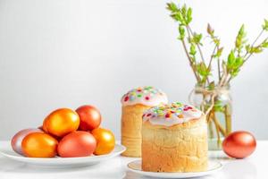 Easter cake panettone with sweet icing and golden eggs on white plate. photo