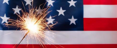 Concept for celebrating US Independence or Memorial Day. Sparkler on a background of American flag. photo