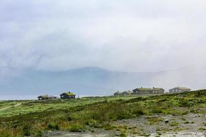 Norway landscape with fog clouds rocks cliffs with cabins Hemsedal. photo