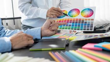 diseñador gráfico o creativo trabajando juntos coloreando usando una tableta gráfica y un lápiz en el escritorio con un colega.