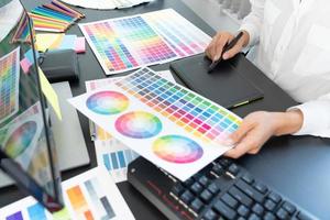 diseñador de interiores o diseñador gráfico creativo que trabaja en proyectos arquitectónicos con muestras de color con herramientas y equipos de trabajo para la selección en la oficina foto