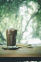 Iced coffee Mocha in a tall glass on wood table. photo