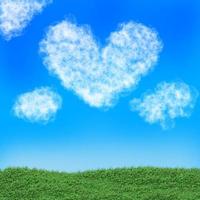 una nube de corazón en el cielo azul y el campo verde. foto