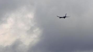 Flugzeug im bewölkten grauen Himmel