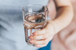 World Water Day. Woman holds glass of clean water in her hands. Health care concept. photo