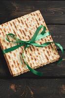 Matzah background. Happy Passover. Traditional Jewish regilious holiday Pesach. Matzo bread on a dark wooden table.