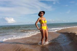 Fit women in a yellow bikini at the beach known as Pitinga, in Arraial d Ajuda, Bahia, Brazil photo