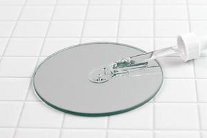 Pipette and serum drops on mirror, cosmetic production photo
