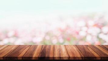 Empty wood table with bokeh flowers in garden background. photo