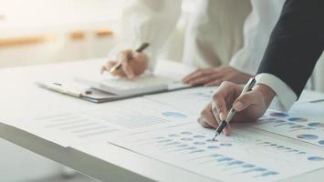 Close up team businesswoman analysis on data paper with business woman using calculator at the office photo