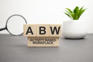 On a wood board, wooden word cubes are arranged in the letters ABW. It is an abbreviation for Activity Based Working. photo