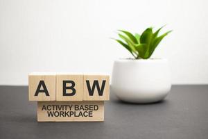 On a wood board, wooden word cubes are arranged in the letters ABW. It is an abbreviation for Activity Based Working. photo