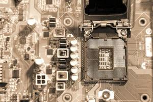 Electronic circuit boards on brown background with CPU socket, selective focus photo