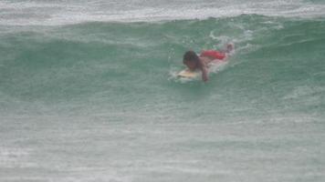 surfare på vågorna vid kraftigt regn video