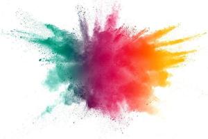 Abstract multi color powder explosion on white background.Freeze motion of dust particles splash. photo