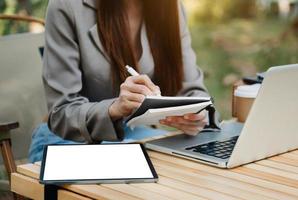 businessman hand working with new modern computer and writing on the notepad photo