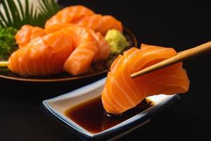 Sashimi, Salmon, Japanese food chopsticks and wasabi on the table photo