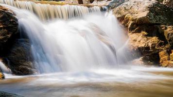 Water flowing along rocks in nature, waterfall photo