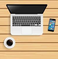 Laptop with cup of coffee and smartphone on wooden table
