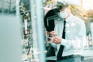 Employees standing at work using their phones while wearing masks during the virus outbreak. photo