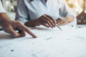 Structural engineering designers are working on the blueprints and analyzing them together. photo