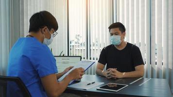 Doctors are explaining the treatment of a patient's illness while wearing a mask during the epidemic. photo