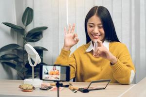 adolescentes asiáticas haciendo vlogs de maquillaje y usando una cámara móvil de video para grabar vlogs y publicarlos en línea en casa. foto