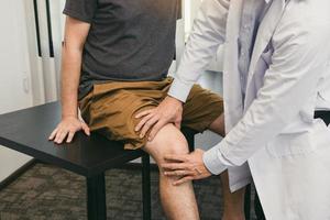 Asian physiotherapists are checking patients' knees.