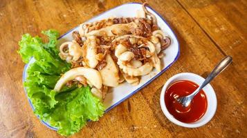 Stir fried squid with crispy garlic and pepper Pla Muek Tod Gra Tium. photo